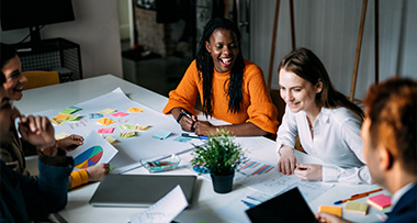 a diverse group of colleagues collaborating in a bright office space during a creative brainstorming session with charts and notes on the table teamwork and ideas