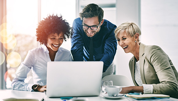 three coworkers collaborating on a laptop in a bright office sharing ideas and enjoying the moment with a focus on teamwork and productivity related to business success 9 strategies