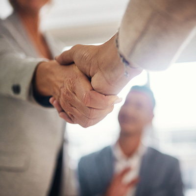 business handshake between two people with a blurred background representing professional agreement and collaboration strategies