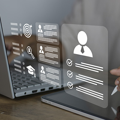 hand holding a stylus writing on a transparent interface displaying data and icons related to profiles and achievements with focus on performance evaluation and assessment including 11 key elements of effective feedback