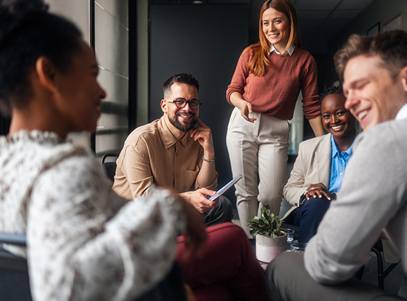 group of five diverse professionals engaging in conversation with a small plant centerpiece discussing ideas and collaboration in a modern office setting focused on teamwork and creativity related to group dynamics 8 strategies for success