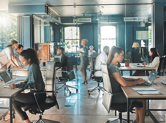 office interior with multiple people working at desks using laptops in a modern environment showcasing collaboration and productivity in a workspace designed for nine professionals